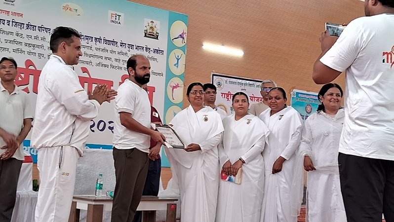 Offering bouquet and saugat to Ditrict Collector Mr. Kumbhar by Archana didi on the occasion of yoga day